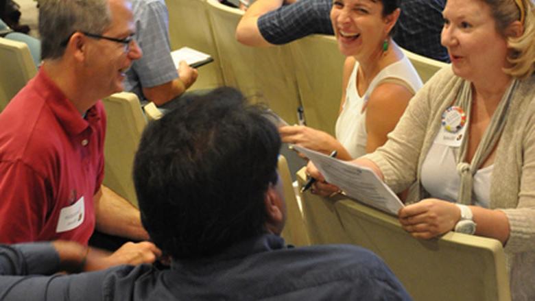 教师 members sit together discussing and laughing